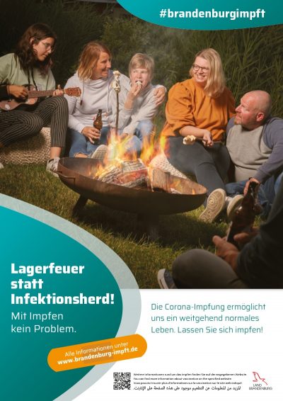 Impfkampagne, fünf Leute die um ein Lagerfeuer sitzen. 