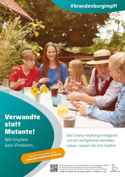 Impfkampagne, fünf Leute die um einen gedeckten Tisch sitzen