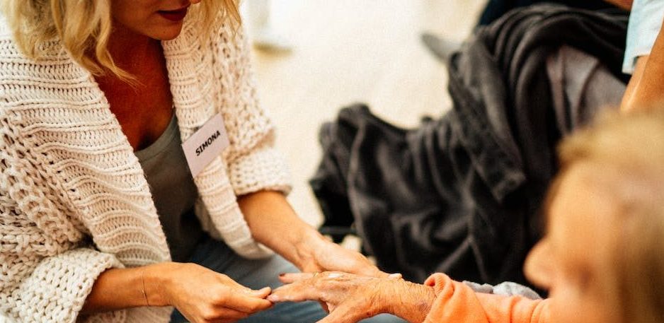 Eine Frau pflegt eine ältere Damen in einem Rollstuhl