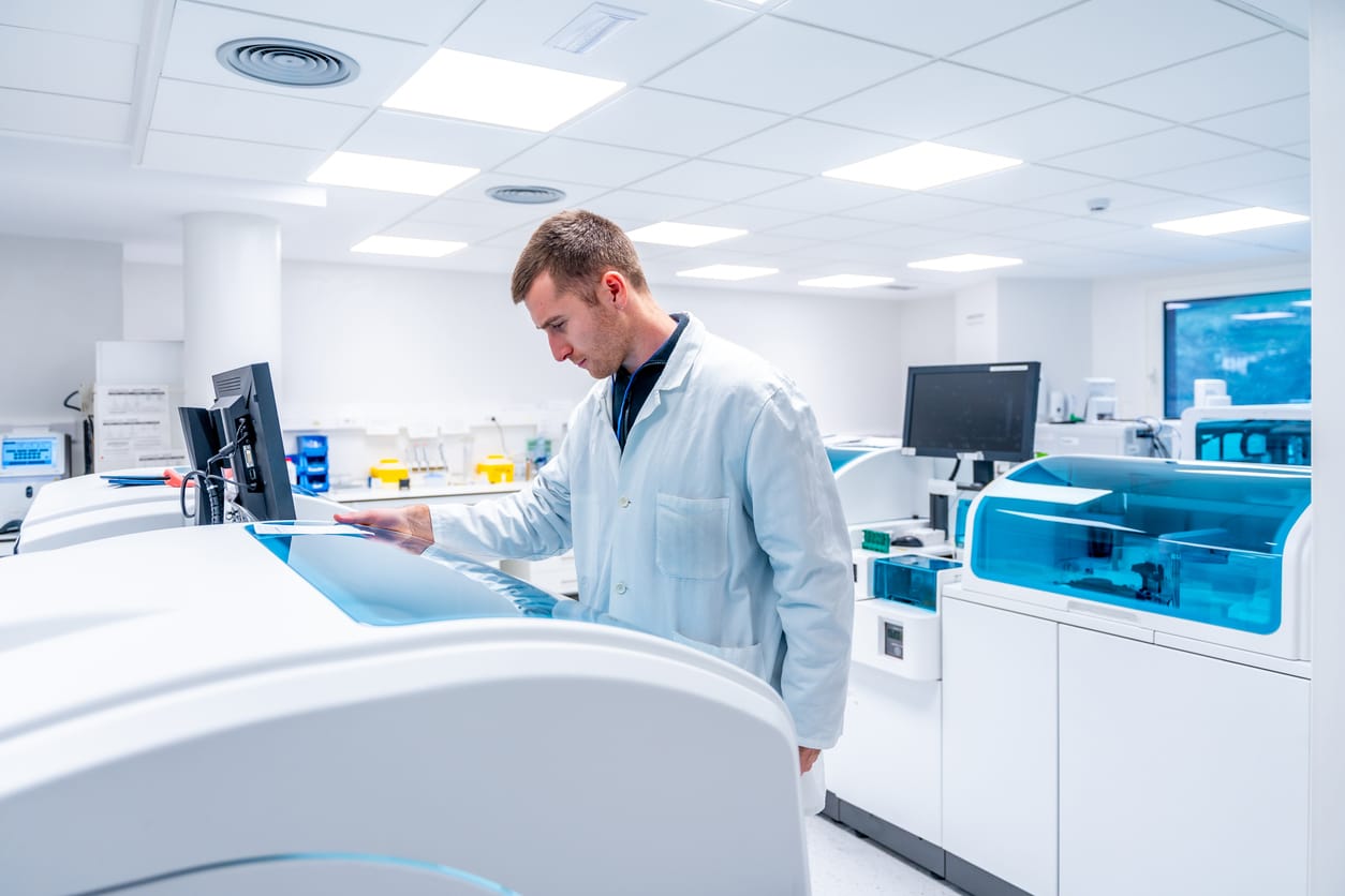 Laboranalytiker bedient moderne Analysegeräte in einem hochtechnisierten, hell beleuchteten Labor